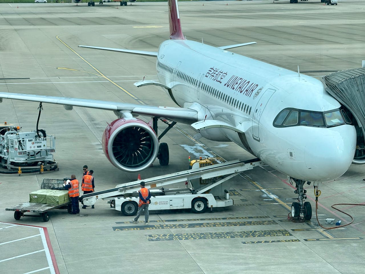 services-01 Airplane being loaded with cargo at the airport terminal with ground crew.