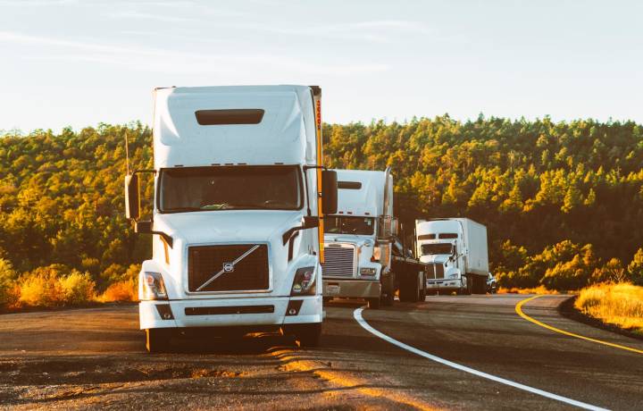 portfolio-04 Three semi trucks driving on a highway through a forested landscape in Arizona.