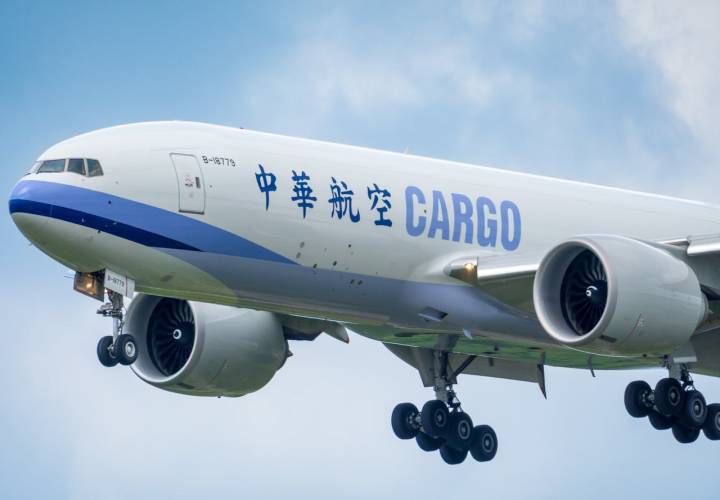 portfolio-07 A large cargo airplane approaches landing under a clear sky.
