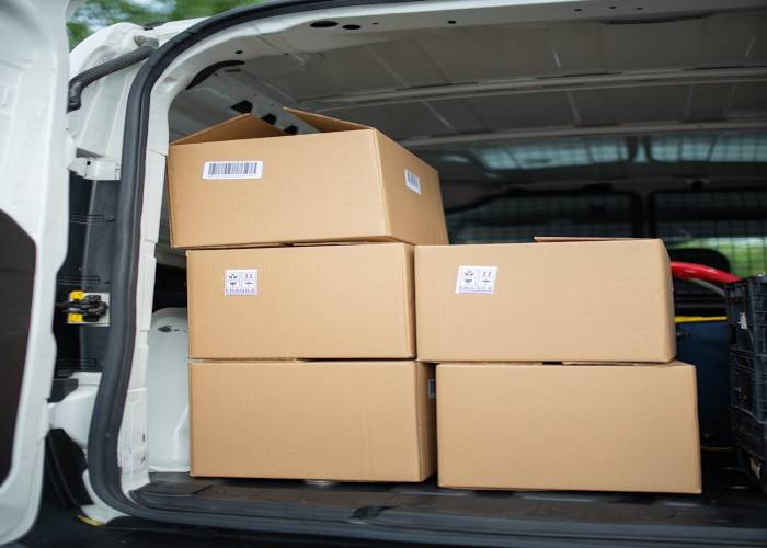 portfolio-03 Stacked cardboard boxes inside an open delivery van, ready for shipment.